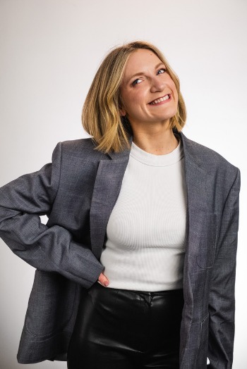 Brydie Rose, smiling, in a grey blazer and white top